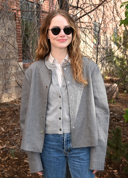 Emma Stone wearing sunglasses and a gray jacket